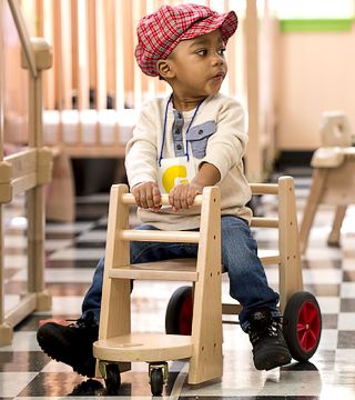 child playing on a kiddie car