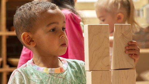 A boy stacking blocks.