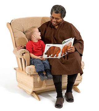 A teacher and a child sit on a glider and read a book