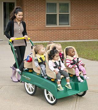 a teacher pushing children in a kindervan stroller