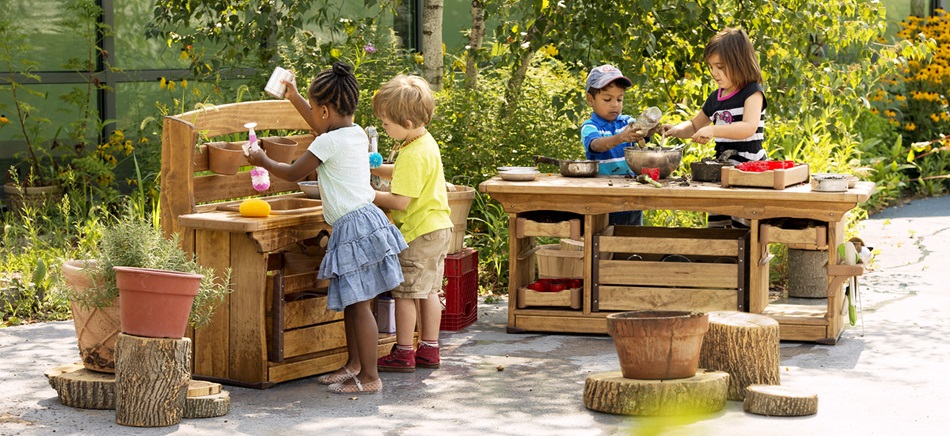 preschool kids playing in a mud kitchen