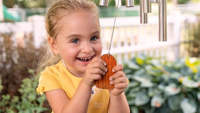 A girl smelling a flower.