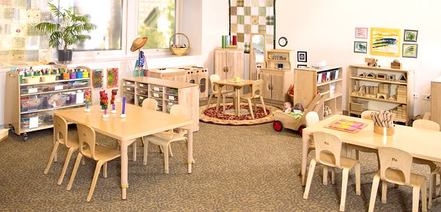 Three children playing in a classroom.