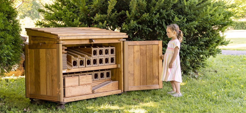 preschool girl looking in toy storage shed