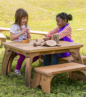 two children sitting at outlast tables